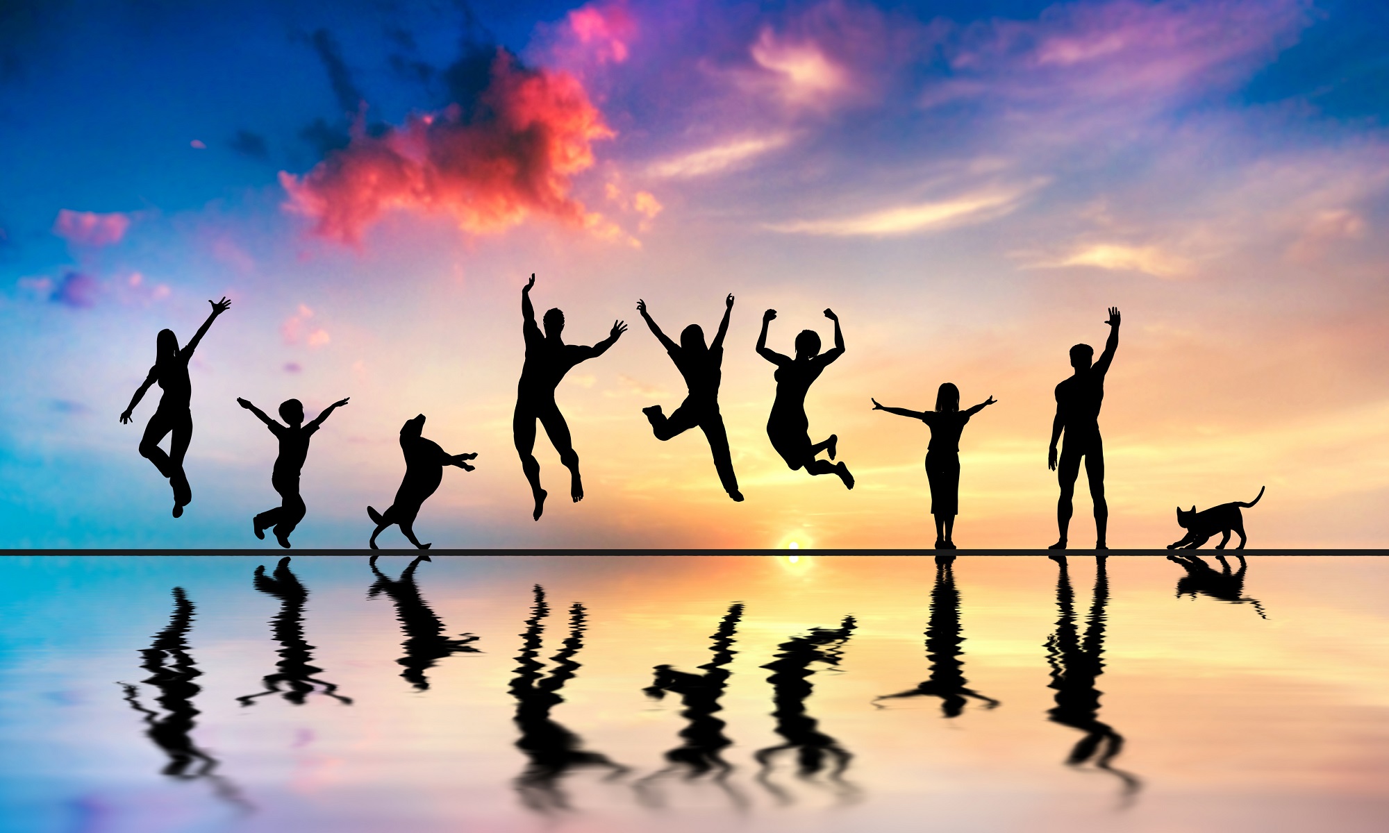 People jumping at beach on sunset