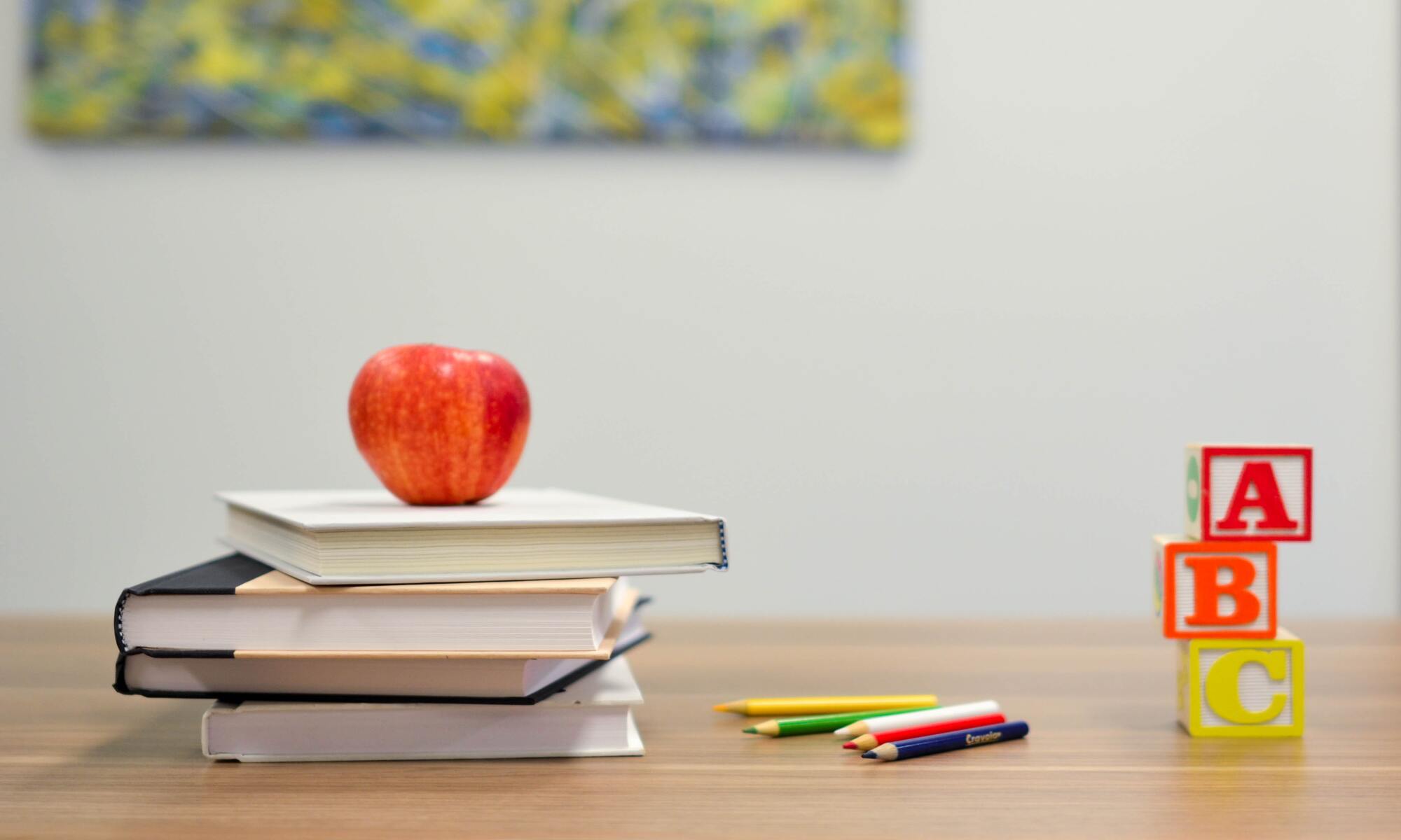 Books and apple on table