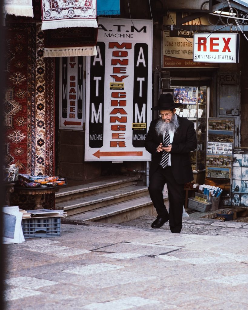 a man in a suit and tie walking down a street